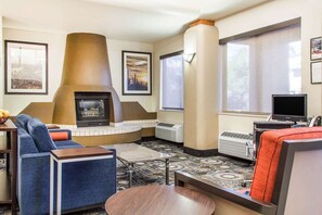 A hotel room with a fireplace, seating area, and large windows. - Fairfield Inn & Suites by Marriott Scottsdale Old Town (Scottsdale)