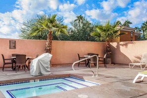 A pool area with lounge chairs and tables, a covered table, and a sign listing spa rules. - Fairfield Inn & Suites by Marriott Scottsdale Old Town (Scottsdale)