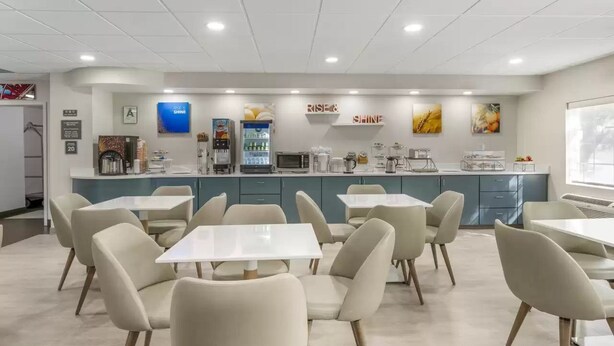 A modern cafe with a counter, seating area, and various food and drink items.