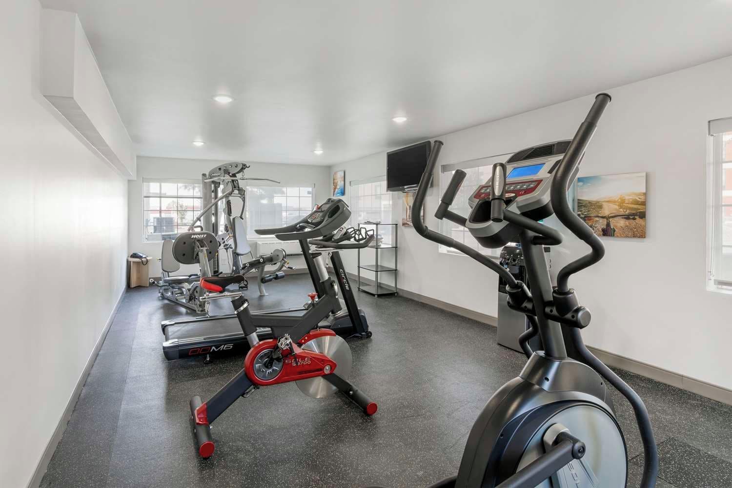 A gym with stationary bikes, a treadmill, and weight machines.