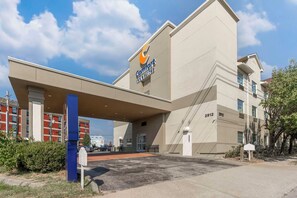 A hotel with a prominent sign for Comfort Inns & Suites, featuring a modern architectural design with a flat roof and a large entrance. - Comfort Inn & Suites Louisville Airport Fair & Expo (Louisville)