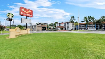 A commercial area with a Starbucks Coffee and Econo Lodge sign, a drive-thru, and a grassy area.