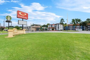 A commercial area with a Starbucks Coffee and Econo Lodge sign, a drive-thru, and a grassy area. - Econo Lodge Augusta North - Washington Road (Augusta)