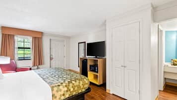 Hotellihuone, jossa on sänky, televisio, mikroaaltouuni ja vaatekaappi.