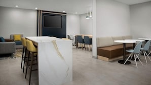 A modern lounge area with a marble bar, seating arrangements, and recessed lighting. - Towneplace Suites by Marriott Birmingham South (Birmingham)