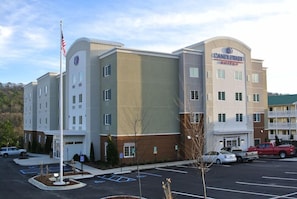 A multi-story hotel with a modern design, featuring a prominent American flag and a sign for Candlewood Suites. - Towneplace Suites by Marriott Birmingham South (Birmingham)