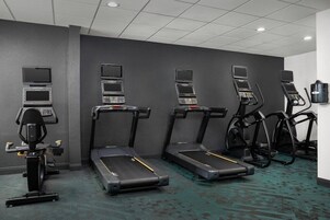 A fitness room with treadmills, ellipticals, and a stationary bike.