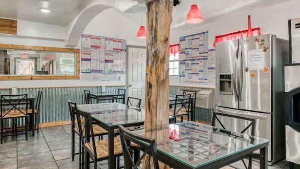 Una cucina moderna con isola centrale, elettrodomestici in acciaio inossidabile e un colonnato in legno rustico.
