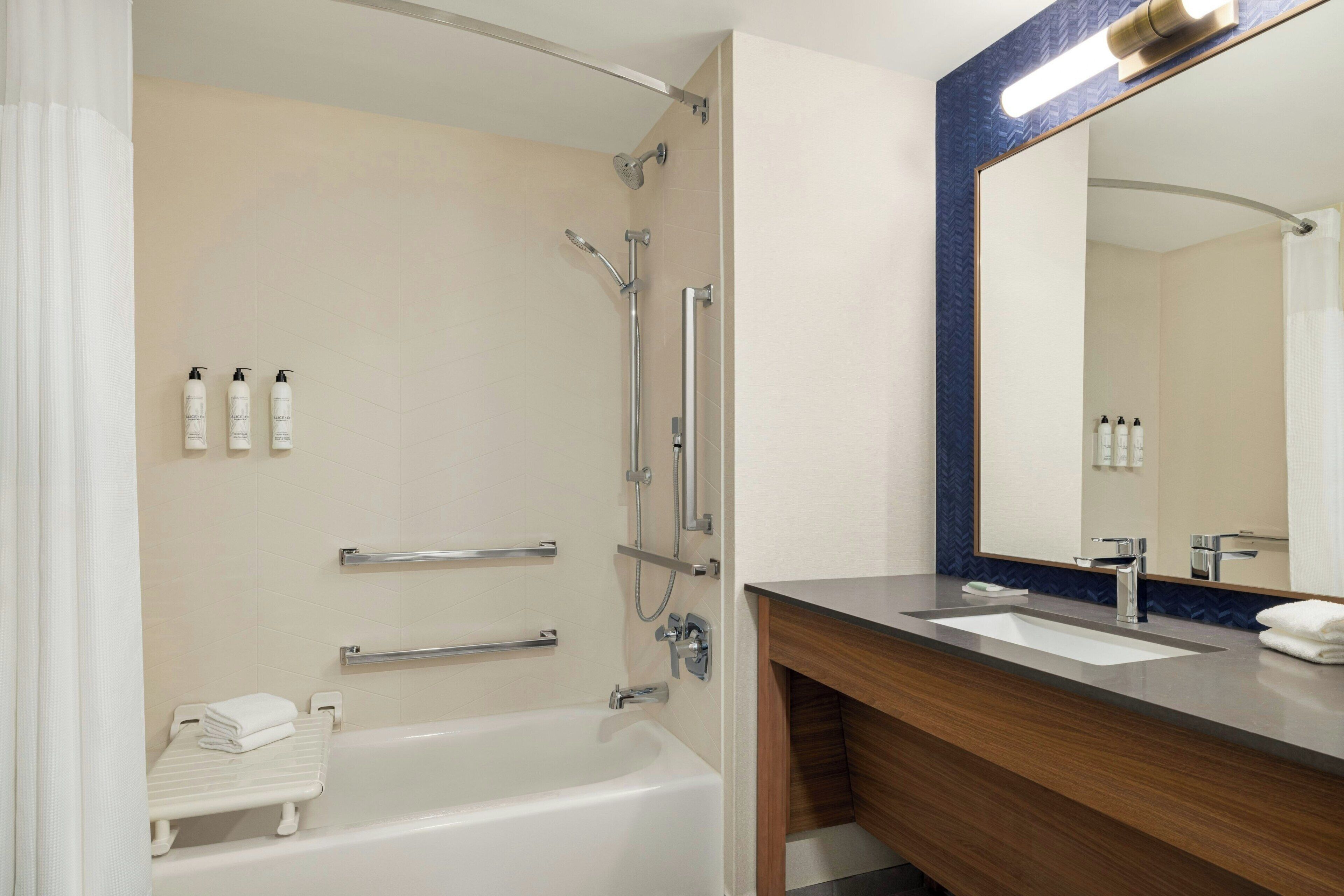 A modern bathroom with a bathtub, a shower, and a vanity with a sink.