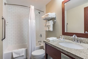 A bathroom with a shower, toilet, sink, and towel rack. - Hotel Monona (Madison)