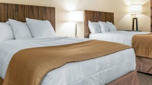 A hotel room with two beds, each with white bedding and a brown throw blanket. There are two bedside lamps and a wooden headboard. - Blisspoint Inn Northwest Indianapolis (Indianapolis)
