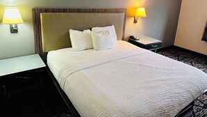 A hotel room with a bed, two bedside tables, and two wall-mounted lamps. - Fairbridge Inn Express Indianapolis Northwest (Indianapolis)