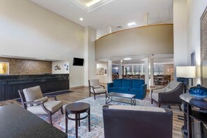 A hotel lobby with a reception desk, seating area, and a dining space. - Best Western Grantville/hershey (Grantville)