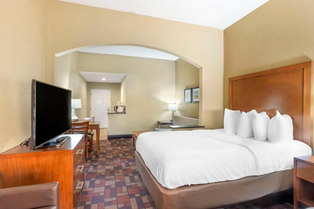 Ein Hotelzimmer mit Bett, Fernseher, Schreibtisch und Stuhl.