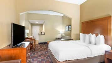 Una habitación de hotel con una cama, televisión, escritorio y una silla.