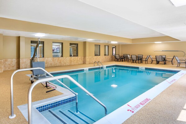 A swimming pool with a 3 ft deep diving area, surrounded by chairs and tables. - Best Western Grantville/hershey (Grantville)