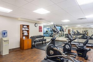 A gym with exercise equipment, a water dispenser, and a mirror. - Best Western Grantville/hershey (Grantville)