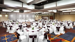 A large banquet hall with round tables set for events, featuring white tablecloths and chairs with dark sashes. - Cleveland Airport Hotel (Cleveland)