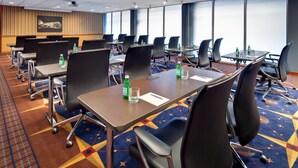 A conference room with tables, chairs, and a carpeted floor. - Cleveland Airport Hotel (Cleveland)