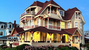 A multi-story house with a balcony, a porch, and a garden. - Spacious, historic, air-conditioned 8-BR 4-BA beauty in the heart of Oak Bluffs (Oak Bluffs)