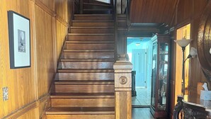 A wooden staircase with a handrail, leading to an upper floor. - Spacious, historic, air-conditioned 8-BR 4-BA beauty in the heart of Oak Bluffs (Oak Bluffs)