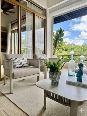 Ein modernes Wohnzimmer mit einer Couch, einem Tisch und einer Zimmerpflanze.