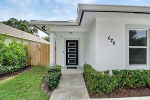 A modern two-story house with a black front door, a mailbox, and a number '626' on the wall. - Stylish 4BR /2 Bath Oasis with Heated Pool, Hot Tub - 10 Mins to Beach/Downtown (West Palm Beach)