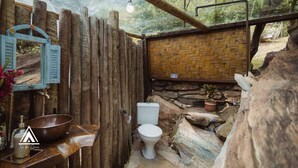 A rustic bathroom with a stone sink, a white toilet, and a woven wall. - Teepee Tipi  da Serra  (Brumadinho)