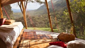 A tented room with a bed, a woven mat, and a view of a mountainous landscape. - Teepee Tipi  da Serra  (Brumadinho)
