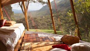 A tented room with a bed, a woven mat, and a view of a mountainous landscape. - Teepee Tipi  da Serra  (Brumadinho)