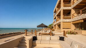 A beachfront resort with a pool area, lounge chairs, and a view of the sea. - Luxury Villas By Awa Holbox - Beachfront (Isla Holbox)