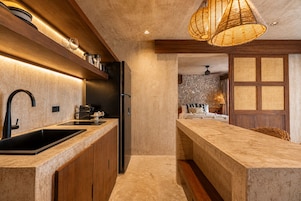 Una cocina moderna con una isla integrada, electrodomésticos de acero inoxidable y una lámpara colgante.