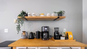 A kitchen counter with coffee makers, a kettle, and a coffee bean bag. - Spacious Roosevelt Urban Lodge + Walk to Light Rail (Seattle)