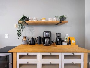 A kitchen counter with coffee makers, a kettle, and a coffee bean bag. - Spacious Roosevelt Urban Lodge + Walk to Light Rail (Seattle)