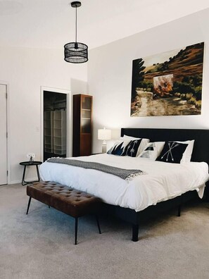 A bedroom with a large bed, a bench, a wardrobe, and a painting on the wall. - Spacious Roosevelt Urban Lodge + Walk to Light Rail (Seattle)