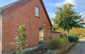 A red brick building with a pitched roof, a window, and a door. - Amazing home in Assens with house sea view (Assens)