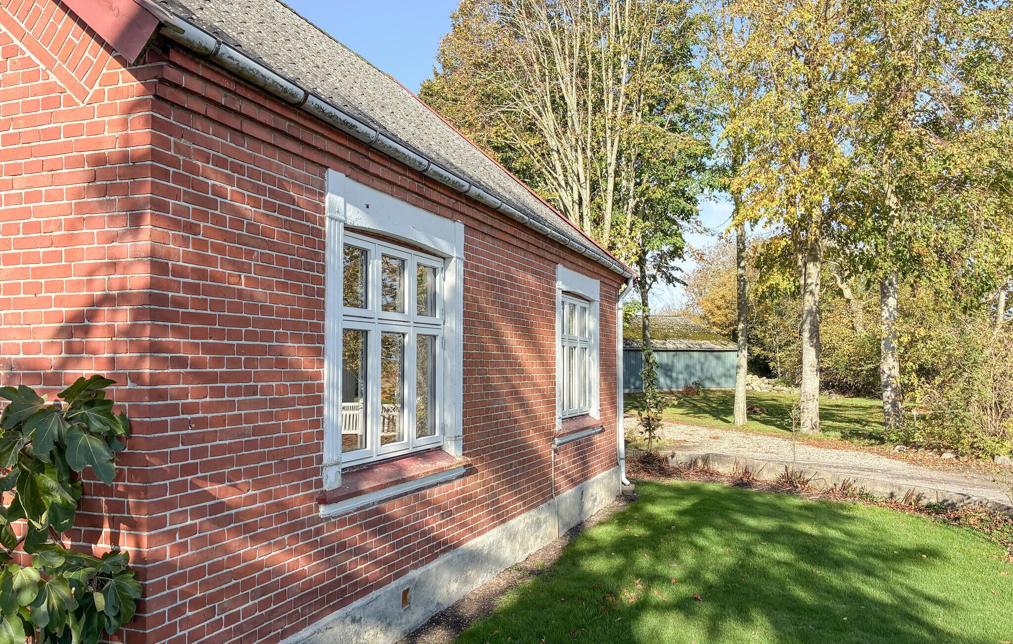 A red brick house with white-framed windows and a small front porch.