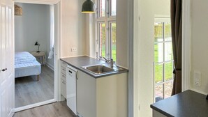 A compact kitchen with a sink, a dishwasher, and a window with a view of greenery. - Amazing home in Assens with house sea view (Assens)