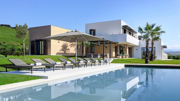 A modern house with a swimming pool, lounge chairs, and a covered patio area. - Rocco Forte Private Villas (Sciacca)