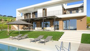 A modern two-story house with a swimming pool, outdoor seating, and a covered patio area. - Rocco Forte Private Villas (Sciacca)