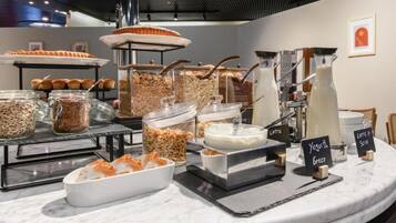 A breakfast buffet with various food items and coffee options.