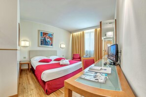 A hotel room with a bed, a desk with a TV, a chair, and a painting on the wall. - B&B Hotel Quarto D'altino (Quarto d'Altino)