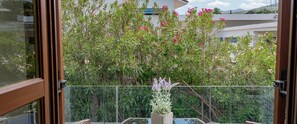 A balcony with a view of a garden and buildings. - Hotel La Conchiglia (Dorgali)