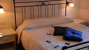 A bed with a metal frame, white bedding, and two bedside lamps.