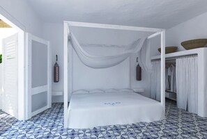 A white four-poster bed with a canopy, a wardrobe with baskets, and a tiled floor. - Mari Del Sud Resort, Vulcano (Lipari)