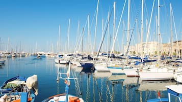 Un port de plaisance où sont amarrés de nombreux voiliers, avec une eau calme et des bâtiments en arrière-plan.