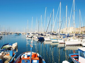 Un port de plaisance où sont amarrés de nombreux voiliers, avec une eau calme et des bâtiments en arrière-plan.