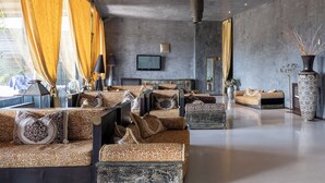 A modern living room with patterned sofas, a flat-screen TV, and a large vase. - Amareclub Baia Dei Turchi Resort - Adults Only (Otranto)