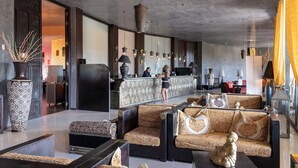 A modern lobby with patterned sofas, a reception desk, and hanging pendant lights. - Amareclub Baia Dei Turchi Resort - Adults Only (Otranto)