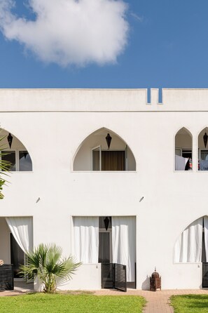Um edifício com várias janelas em arco e telhado plano.